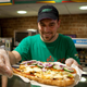 Subway employee handing off a footlong sub over the counter